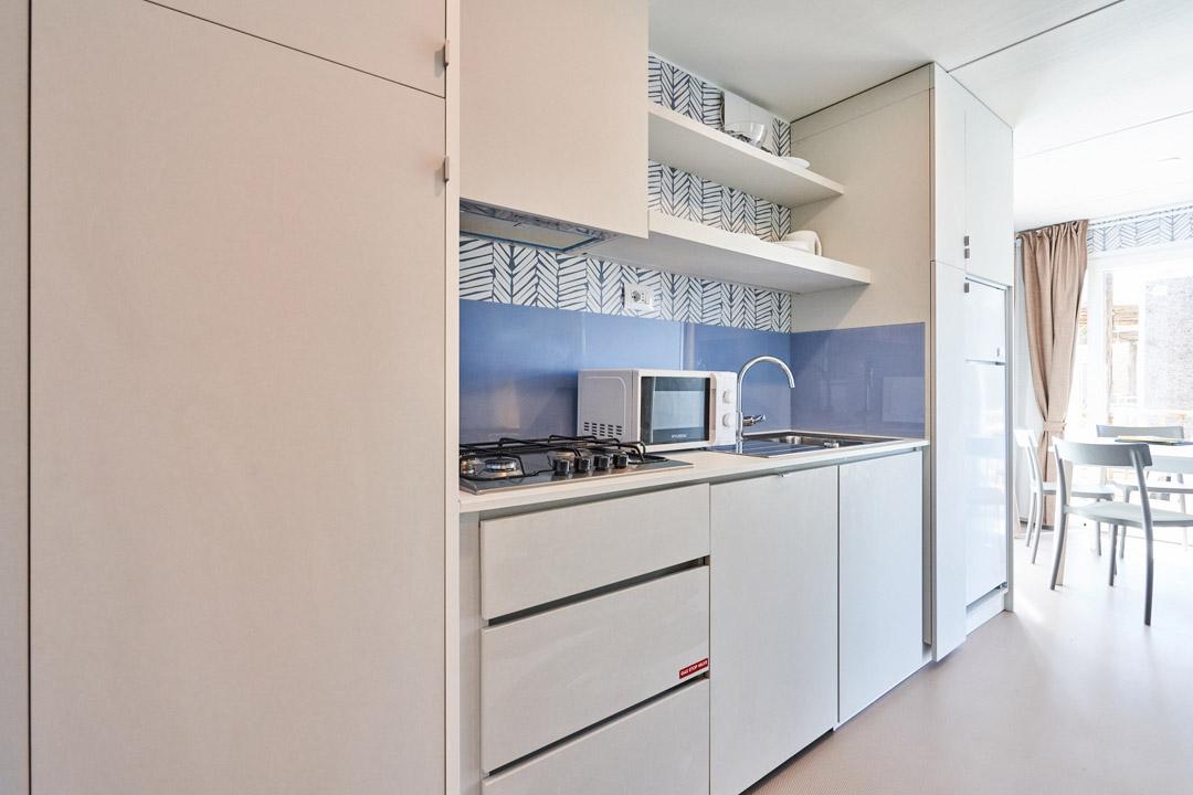 Moderne keuken met apparaten en open planken.