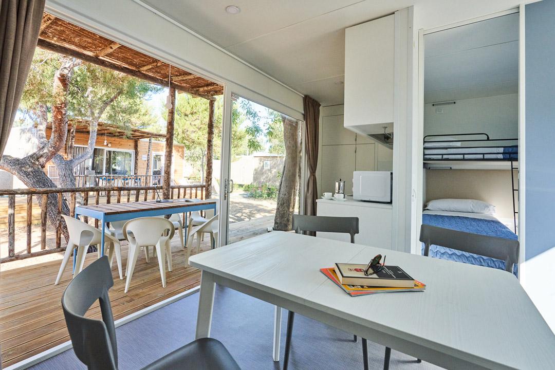 Interior of a holiday home with patio, kitchen, and bunk bed room.